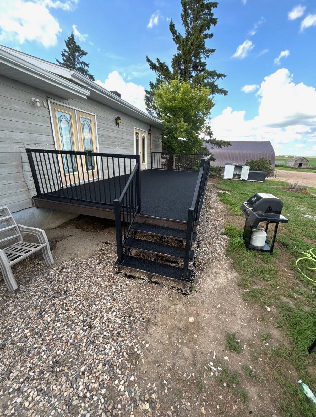 Rubber-surfaced backyard deck with railing and steps