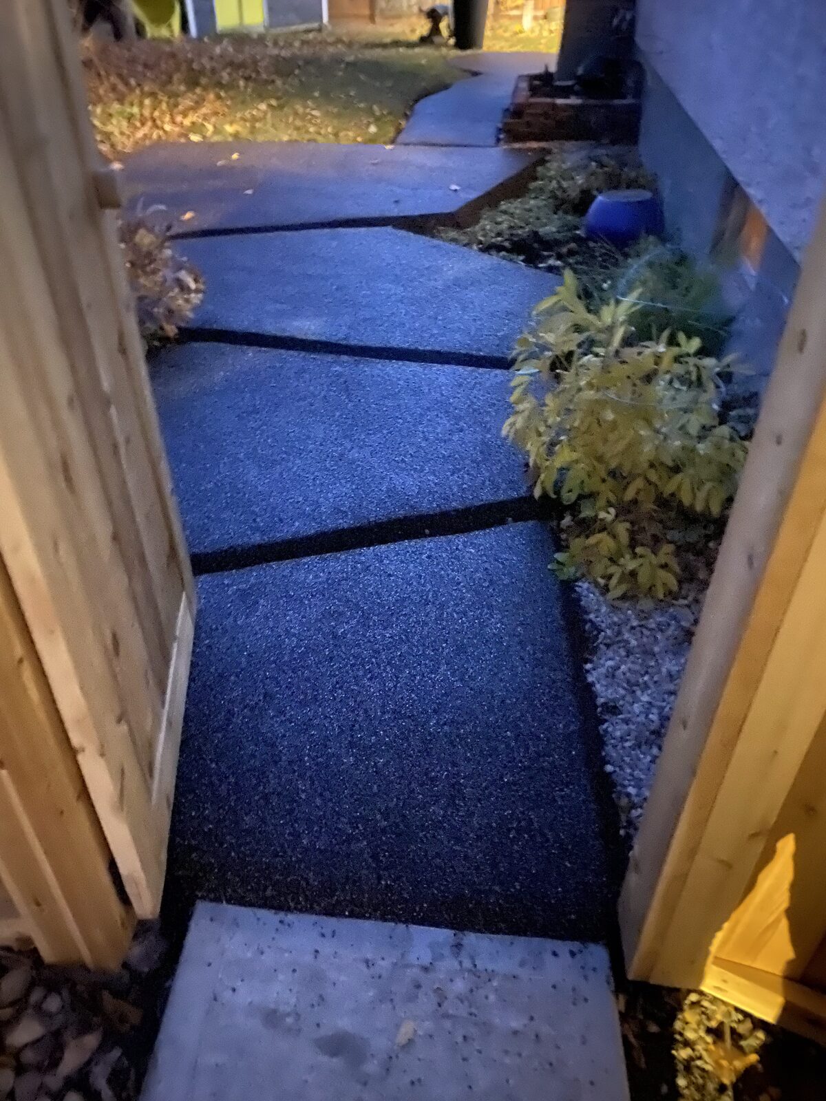 Black rubber walkway running alongside a home