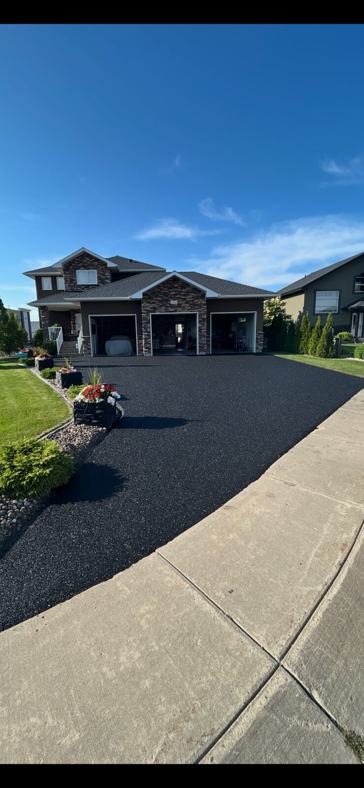 Black rubber resurfaced driveway at a residential home