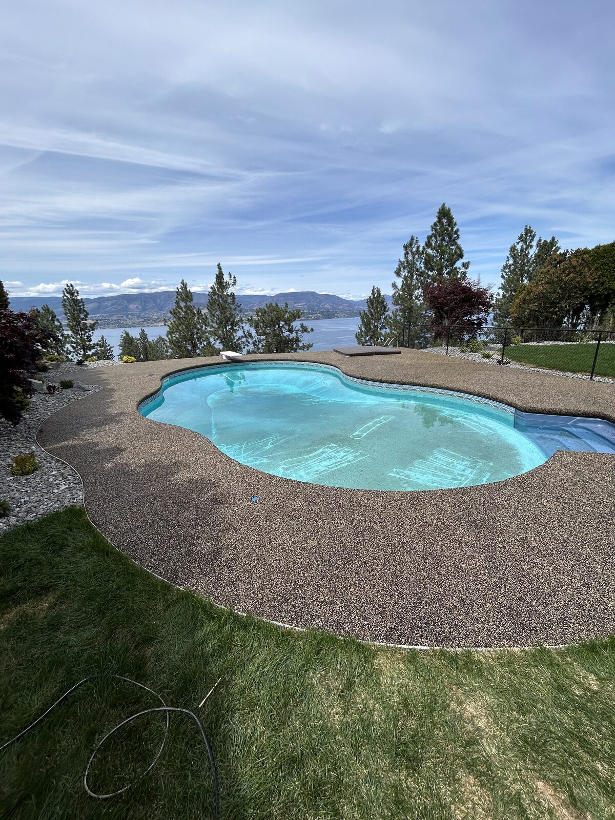 Rubber pool deck surrounding a backyard pool