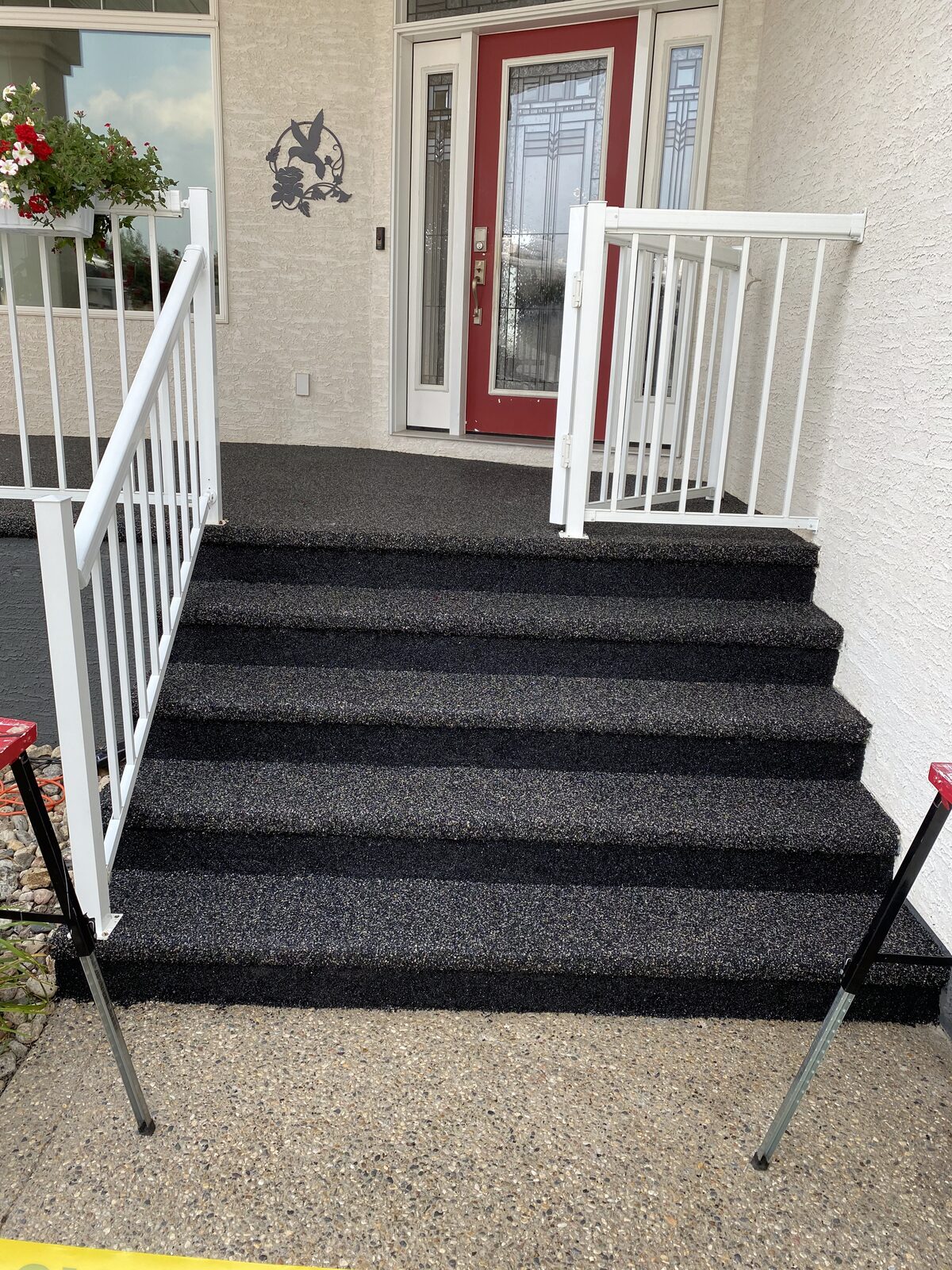 Rubber-surfaced front steps with a white railing